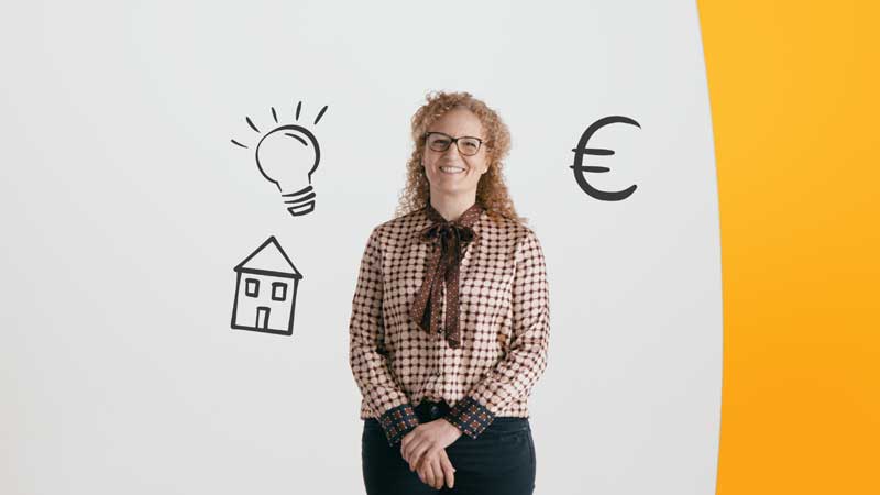 Eine Frau steht vor einer grauen Wand, auf der Symbole aus dem Projekt Stromspar-Check zu finden sind